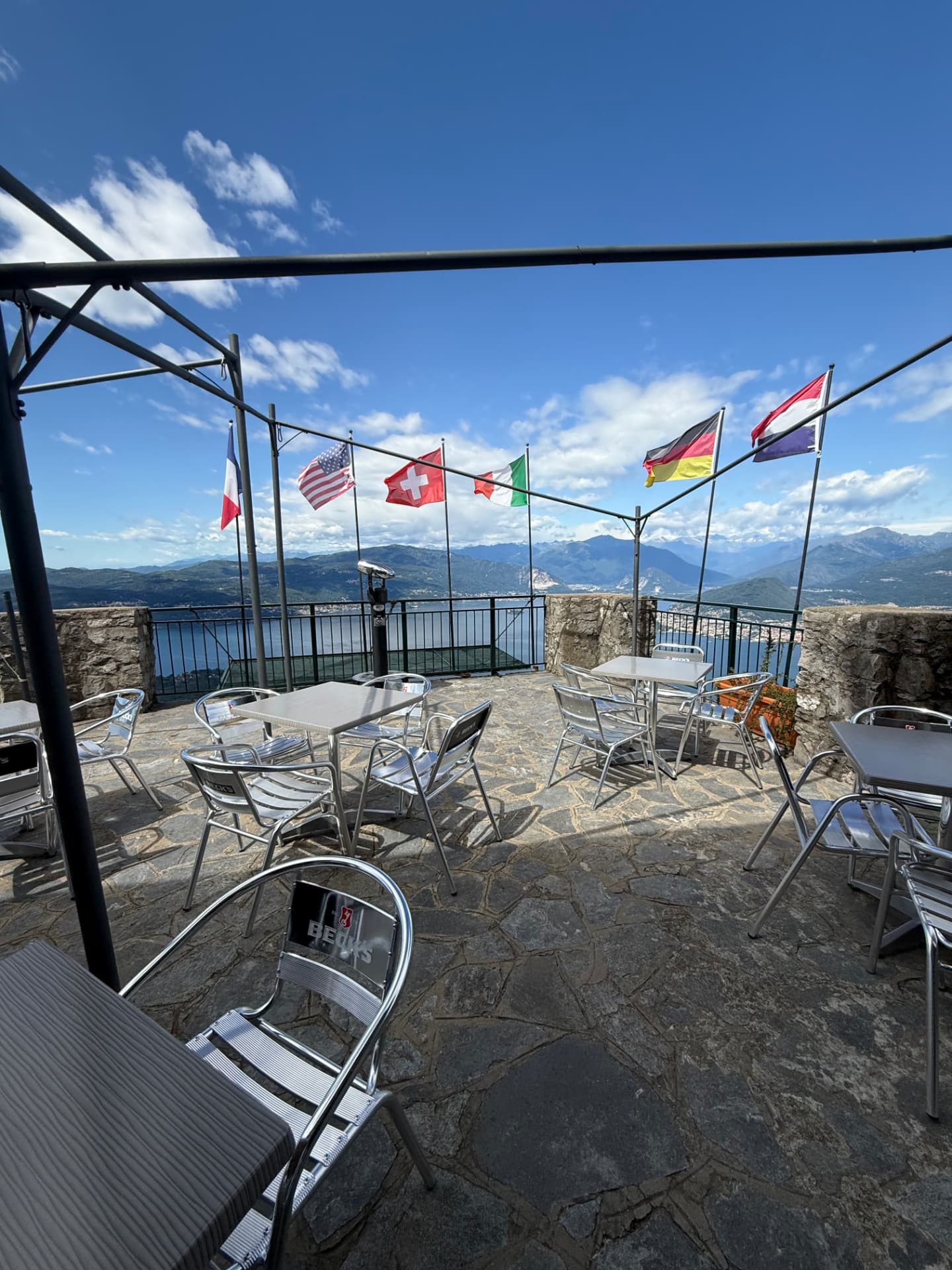 Tavoli della terrazza del bar con le bandiere e il Lago Maggiore