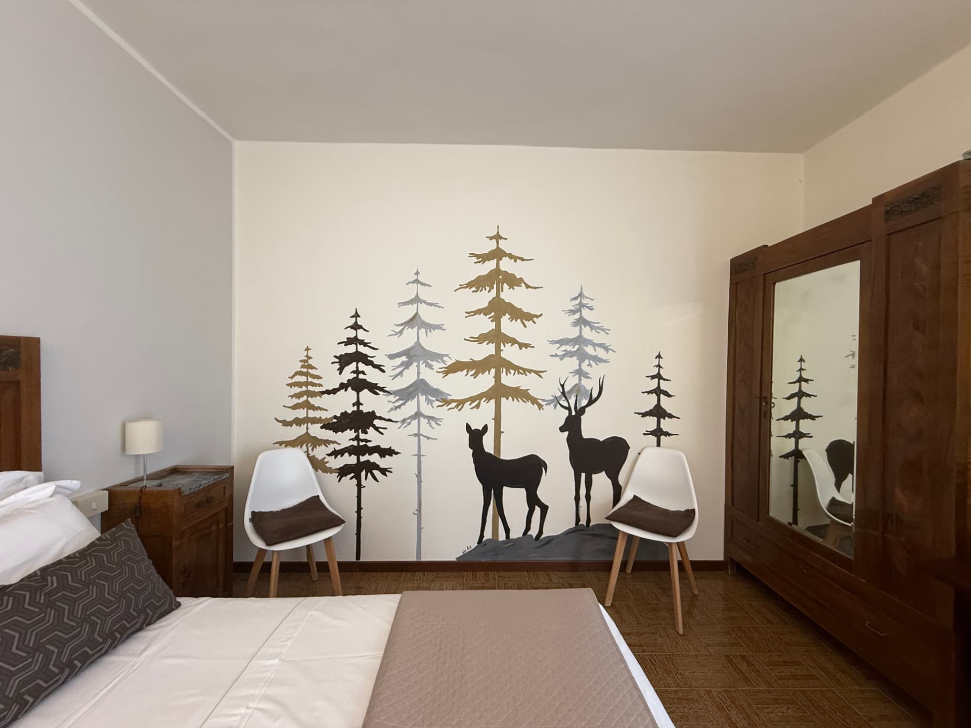 Camera con murale del bosco e arredi in legno